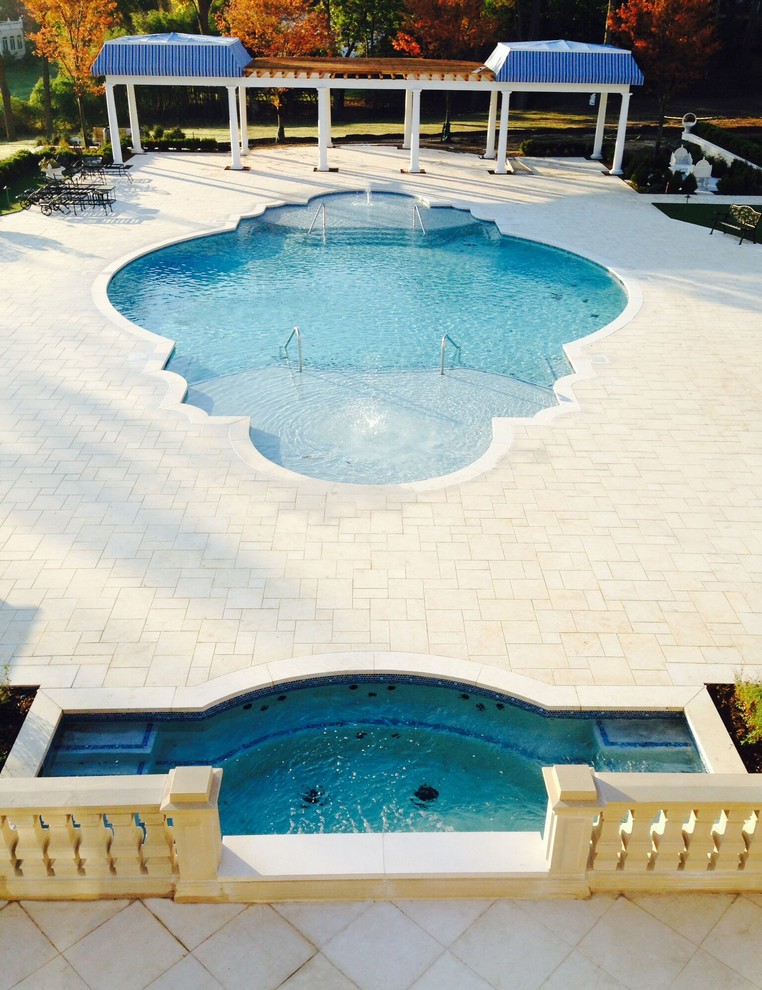 Large backyard stone lap hot tub photo in New York