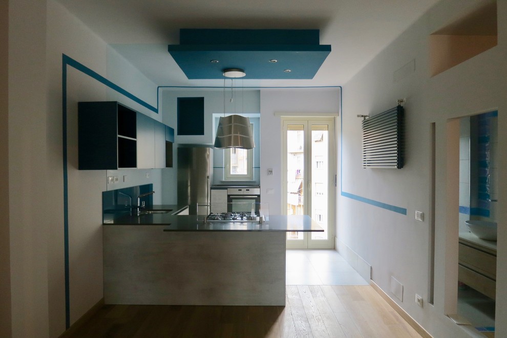 Small contemporary u-shaped open plan kitchen in Turin with an undermount sink, flat-panel cabinets, grey cabinets, quartz benchtops, stainless steel appliances, light hardwood floors, a peninsula and turquoise benchtop.