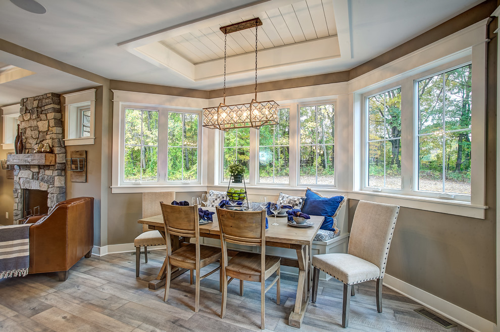 Transitional light wood floor kitchen/dining room combo photo in Grand Rapids with beige walls, a standard fireplace and a stone fireplace