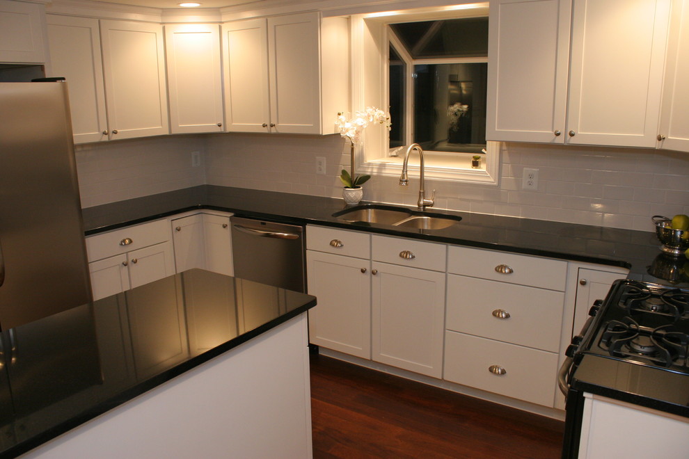 Mid-sized minimalist u-shaped dark wood floor eat-in kitchen photo in Baltimore with an undermount sink, shaker cabinets, white cabinets, granite countertops, white backsplash, subway tile backsplash, stainless steel appliances and an island