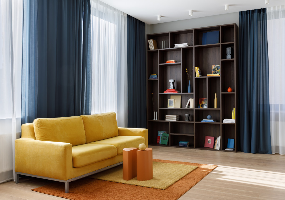 Photo of a contemporary living room with a library and beige walls.