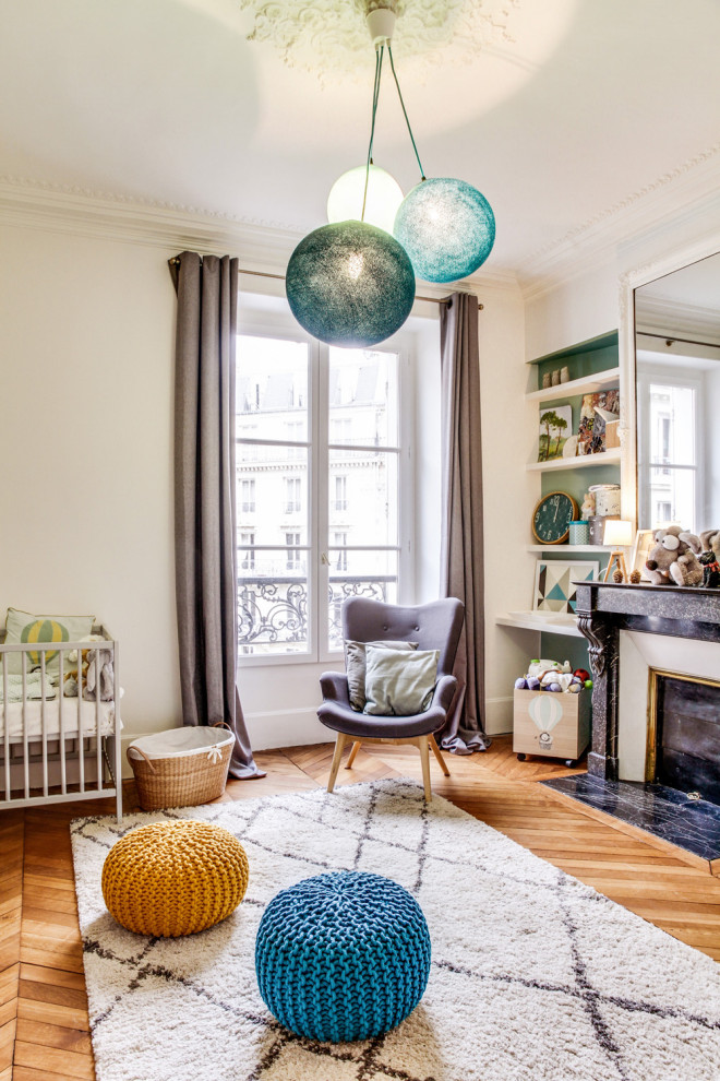 This is an example of a mid-sized scandinavian gender-neutral nursery in Paris with white walls, brown floor and light hardwood floors.