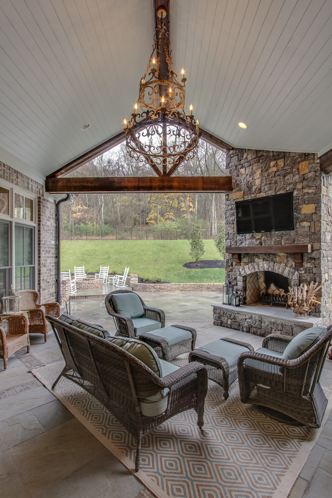 This is an example of a traditional patio in Nashville with a roof extension and with fireplace.