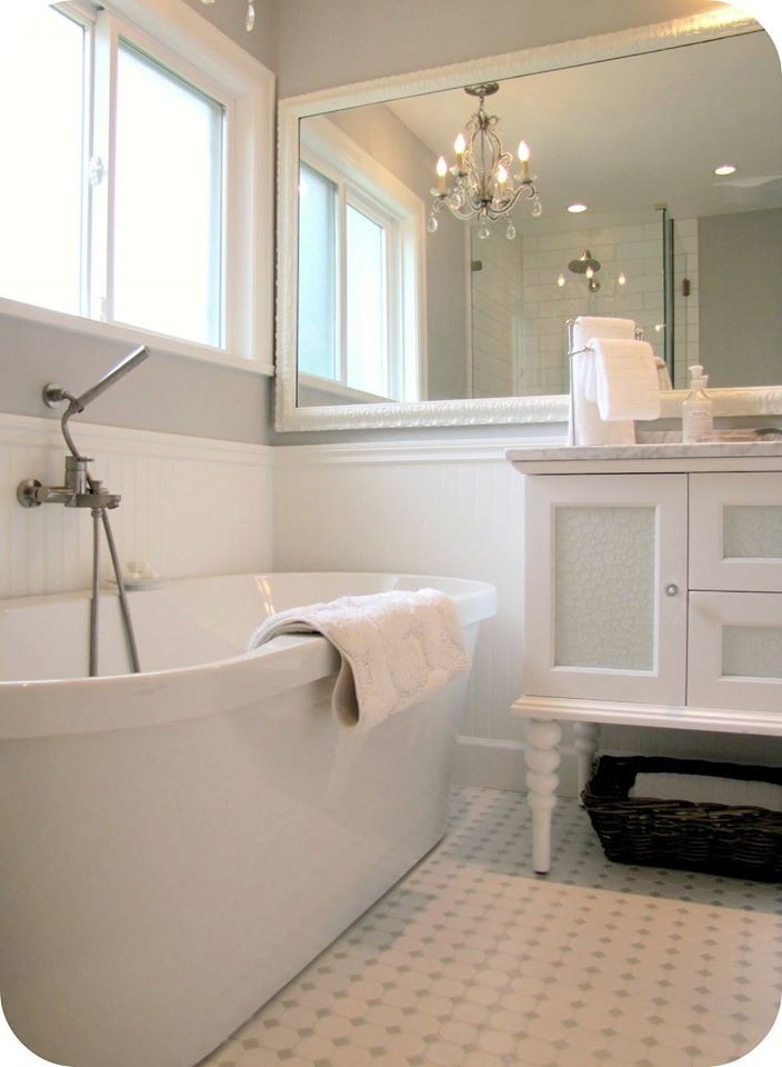 Example of a mid-sized transitional master white tile and subway tile ceramic tile freestanding bathtub design in Milwaukee with glass-front cabinets, white cabinets, white walls, an undermount sink and marble countertops