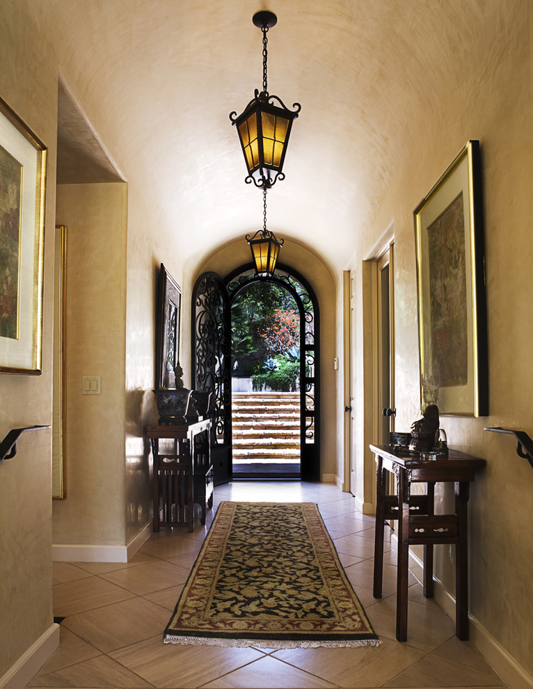 This is an example of a mediterranean entry hall in Santa Barbara with beige walls, a single front door and a metal front door.
