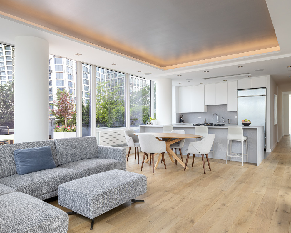 Immagine di un soggiorno minimalista di medie dimensioni e aperto con angolo bar, pareti bianche, parquet chiaro, pavimento beige e soffitto a cassettoni