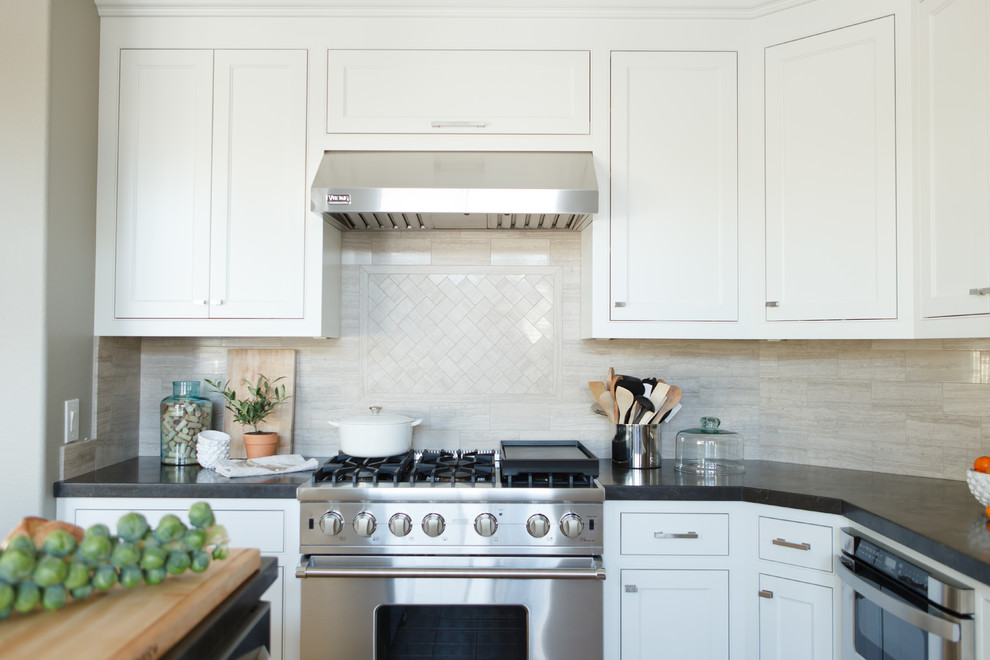 Example of a large transitional l-shaped light wood floor open concept kitchen design in Orange County with a farmhouse sink, beaded inset cabinets, white cabinets, beige backsplash, stone tile backsplash, stainless steel appliances, gray walls and an island
