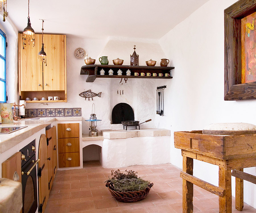 Small mediterranean u-shaped eat-in kitchen in Other with an integrated sink, open cabinets, medium wood cabinets, limestone benchtops, multi-coloured splashback, ceramic splashback, white appliances, no island and terra-cotta floors.