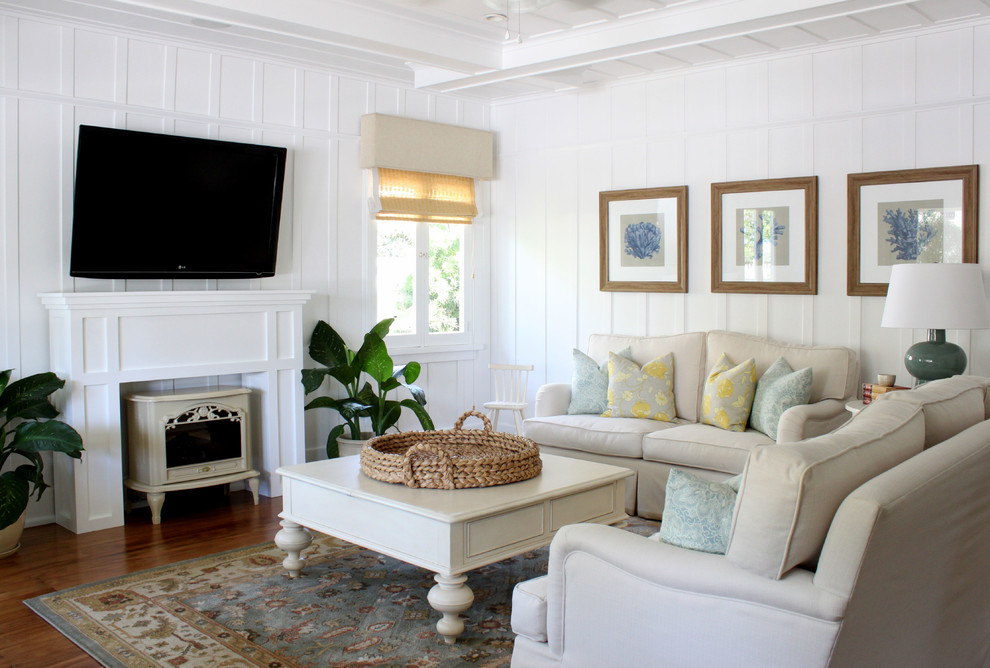 Inspiration for a traditional living room in Orange County with white walls, a wall-mounted tv and a wood stove.