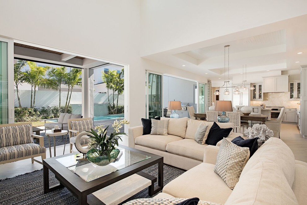 Photo of an expansive contemporary open concept family room in Miami with white walls, light hardwood floors, a ribbon fireplace, a plaster fireplace surround, a built-in media wall and beige floor.