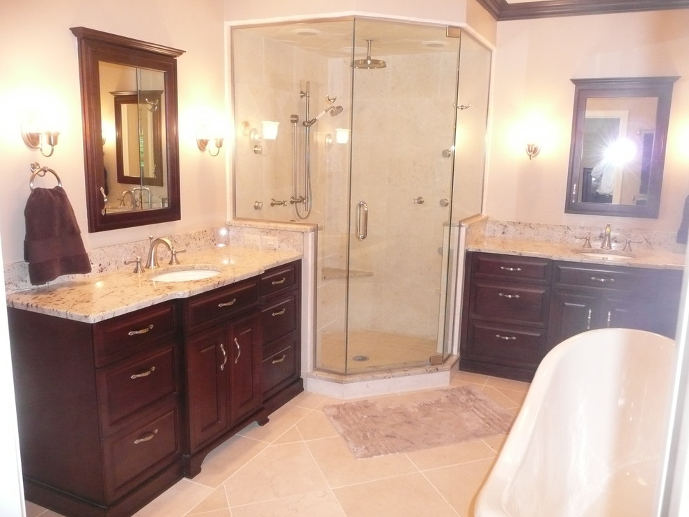 This is an example of a traditional master bathroom in Detroit with a drop-in sink, recessed-panel cabinets, dark wood cabinets, granite benchtops, a freestanding tub, a corner shower, beige tile, ceramic tile, beige walls and ceramic floors.