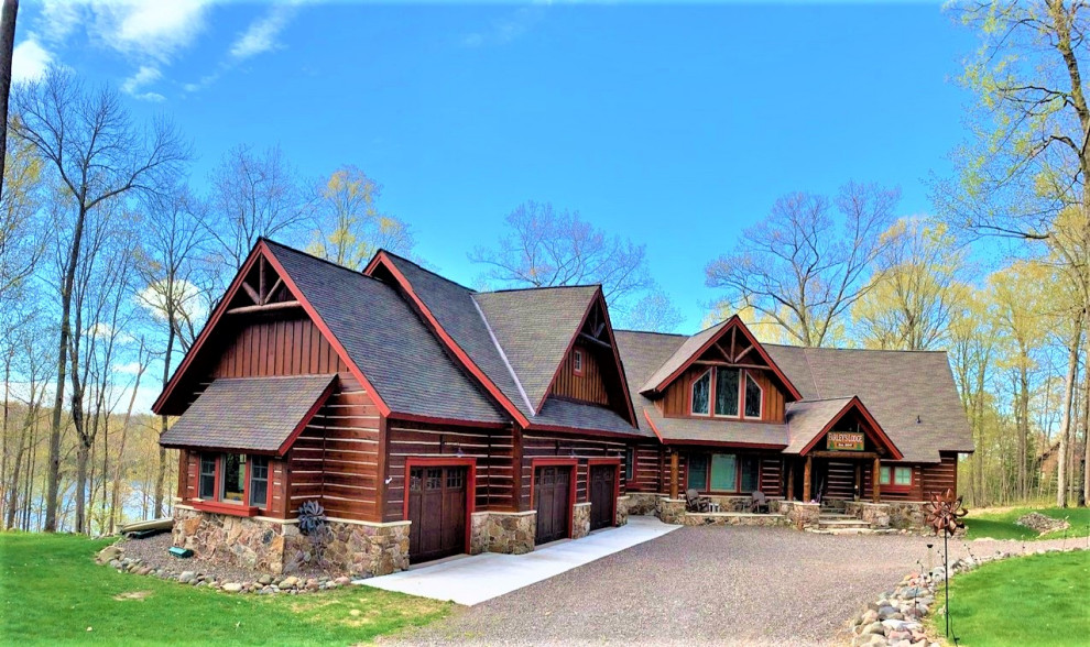 Inspiration for an expansive country two-storey brown house exterior in Minneapolis with wood siding, a shingle roof and a brown roof.
