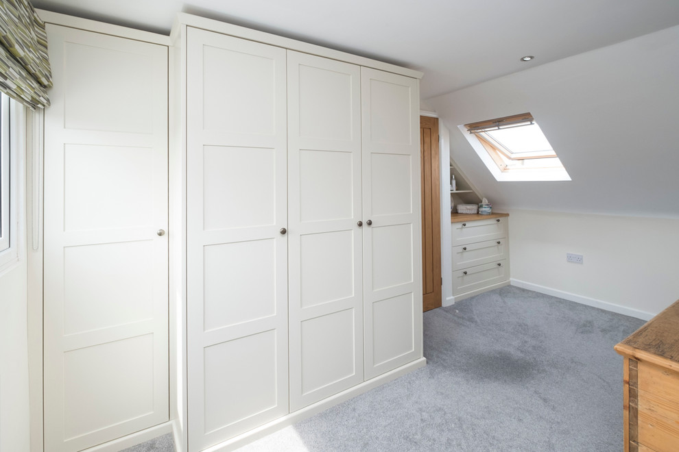This is an example of a mid-sized traditional dressing room in Cardiff with shaker cabinets, white cabinets and carpet.