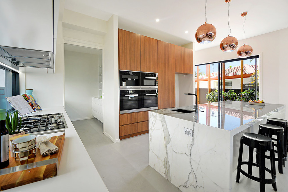 Photo of a contemporary kitchen in Gold Coast - Tweed with an undermount sink, flat-panel cabinets, medium wood cabinets, stainless steel appliances and with island.