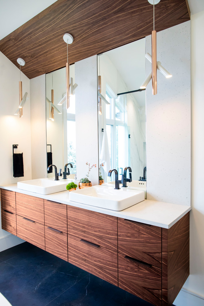 Photo of a large modern master bathroom in Toronto with flat-panel cabinets, medium wood cabinets, a japanese tub, a curbless shower, a bidet, white tile, porcelain tile, white walls, porcelain floors, a vessel sink, engineered quartz benchtops, black floor, a hinged shower door and white benchtops.