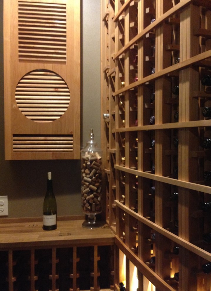 This is an example of a small traditional wine cellar in Dallas with storage racks and brown floor.