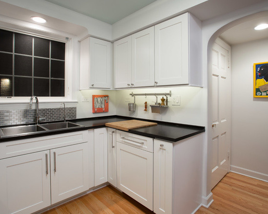 Inspiration for a mid-sized transitional u-shaped medium tone wood floor enclosed kitchen remodel in Chicago with a double-bowl sink, shaker cabinets, white cabinets, quartzite countertops, gray backsplash, subway tile backsplash, stainless steel appliances and no island