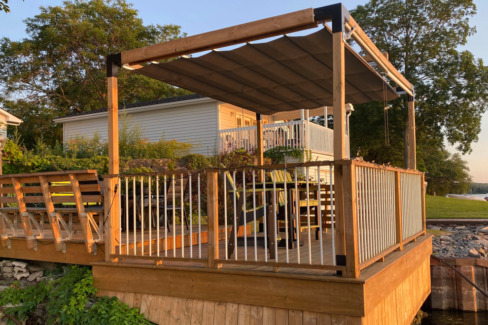 Design ideas for a beach style back ground level mixed railing terrace in Toronto with a pergola.