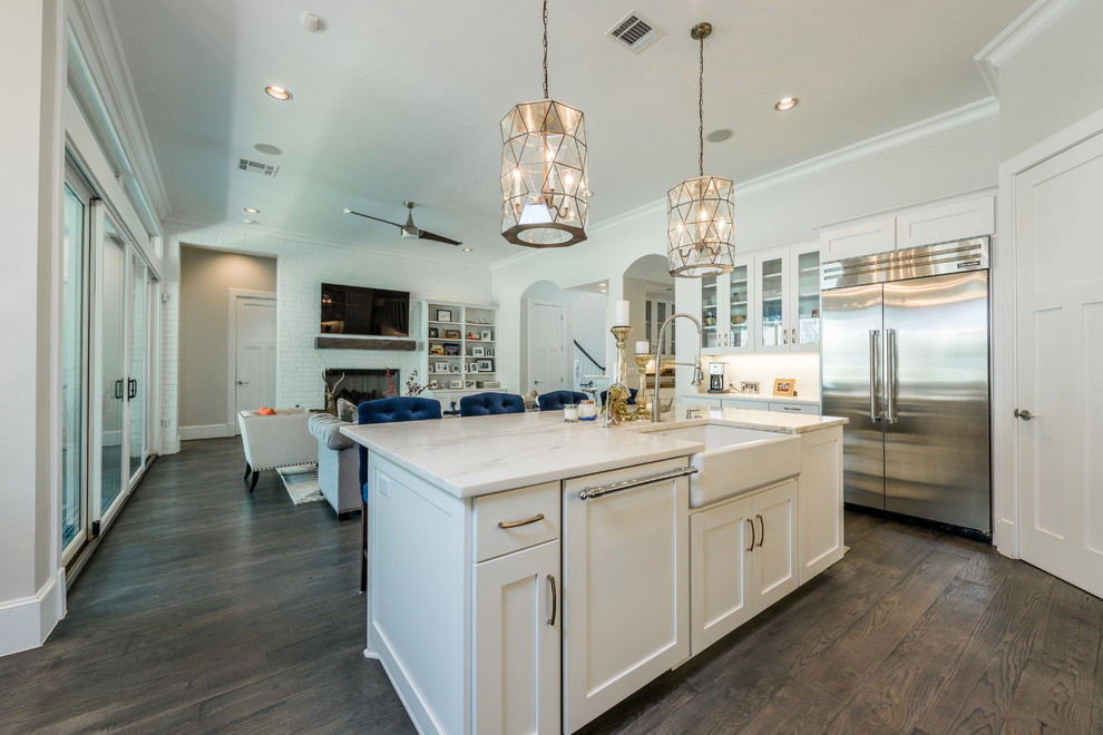 Example of a large transitional dark wood floor kitchen design in Austin with a farmhouse sink, shaker cabinets, white cabinets, marble countertops, white backsplash, stainless steel appliances and an island