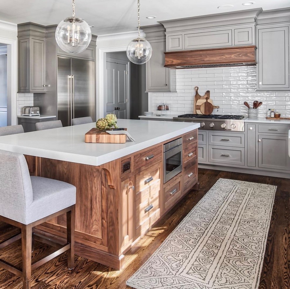 Design ideas for an expansive traditional separate kitchen in Dallas with shaker cabinets, grey cabinets, white splashback, subway tile splashback, stainless steel appliances, dark hardwood floors, with island, brown floor and white benchtop.