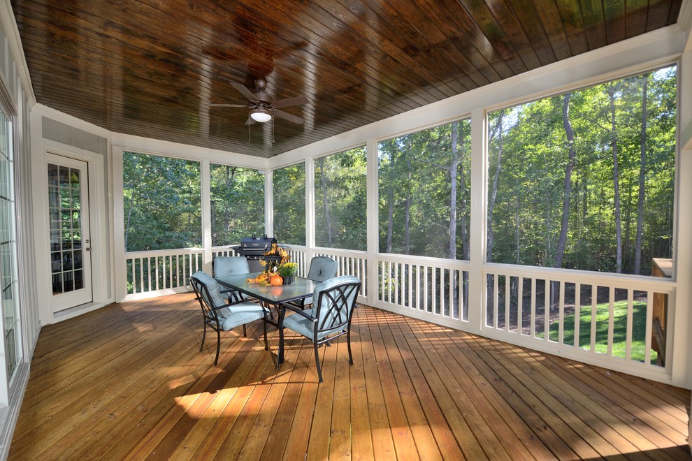 This is an example of a traditional backyard screened-in verandah in Raleigh with decking and a roof extension.