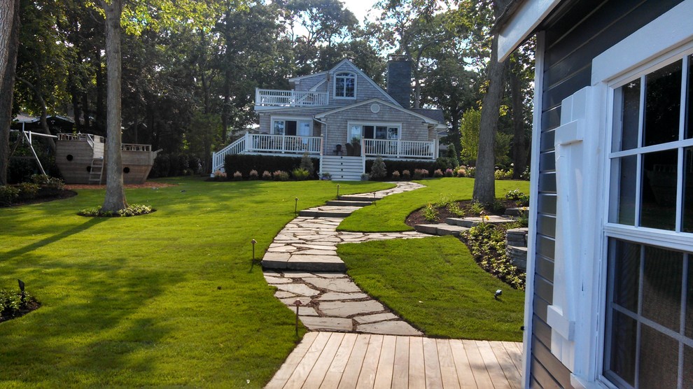 Large country backyard full sun garden in New York with a garden path and natural stone pavers for spring.