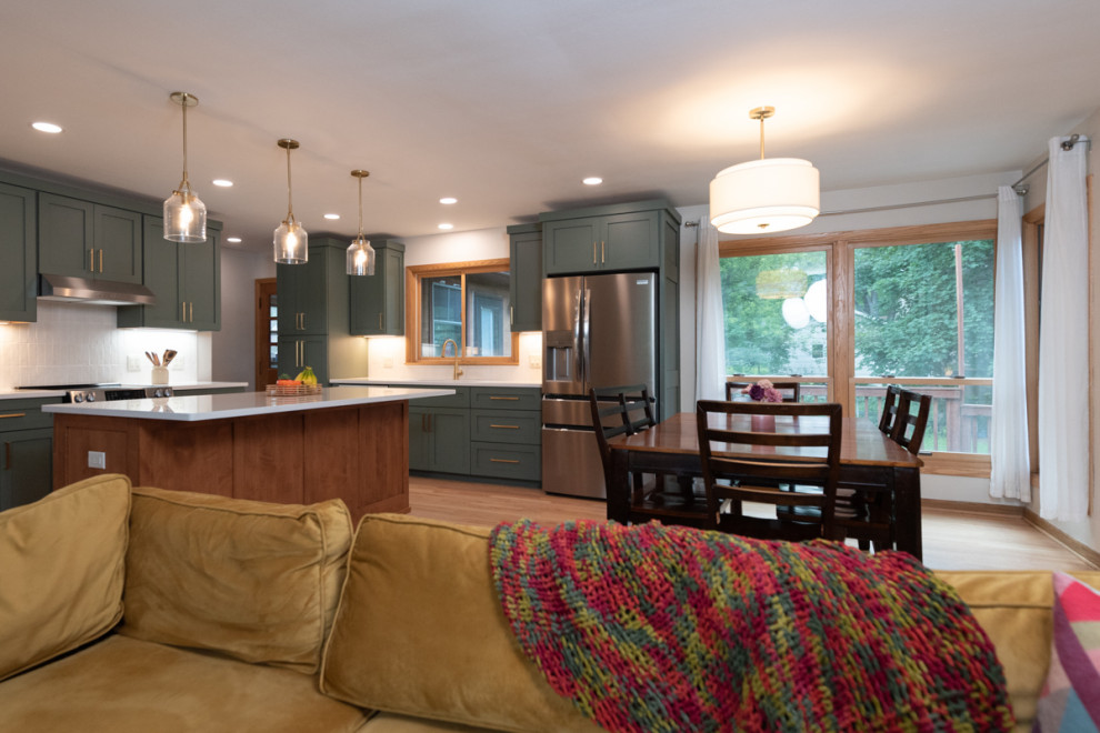 Inspiration for a transitional light wood floor kitchen remodel with shaker cabinets, green cabinets, quartz countertops, white backsplash, ceramic backsplash and an island