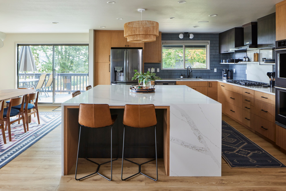 Eat-in kitchen - large mid-century modern l-shaped vinyl floor eat-in kitchen idea in Seattle with an undermount sink, flat-panel cabinets, medium tone wood cabinets, quartz countertops, blue backsplash, porcelain backsplash, stainless steel appliances, an island and white countertops