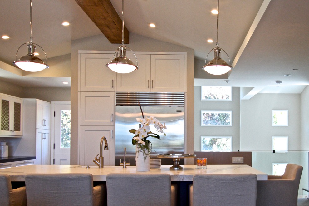 Example of a large transitional single-wall dark wood floor eat-in kitchen design in Orange County with a farmhouse sink, shaker cabinets, white cabinets, marble countertops, white backsplash, subway tile backsplash, stainless steel appliances and an island