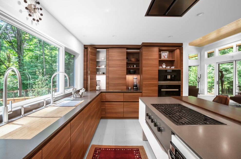 Inspiration for a mid-sized midcentury u-shaped open plan kitchen in Grand Rapids with an undermount sink, flat-panel cabinets, brown cabinets, quartz benchtops, grey splashback, engineered quartz splashback, stainless steel appliances, porcelain floors, with island, white floor and grey benchtop.