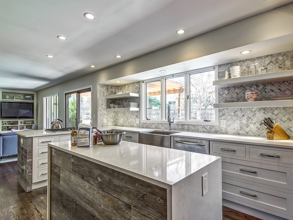 Inspiration for a transitional dark wood floor kitchen remodel in Denver with a farmhouse sink, shaker cabinets, white cabinets, quartz countertops, stone tile backsplash and an island