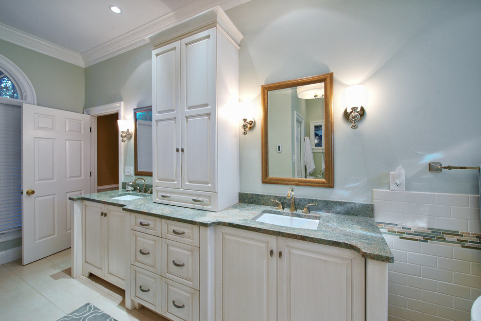 Large transitional master beige tile and subway tile porcelain tile freestanding bathtub photo with raised-panel cabinets, beige cabinets, blue walls and an undermount sink