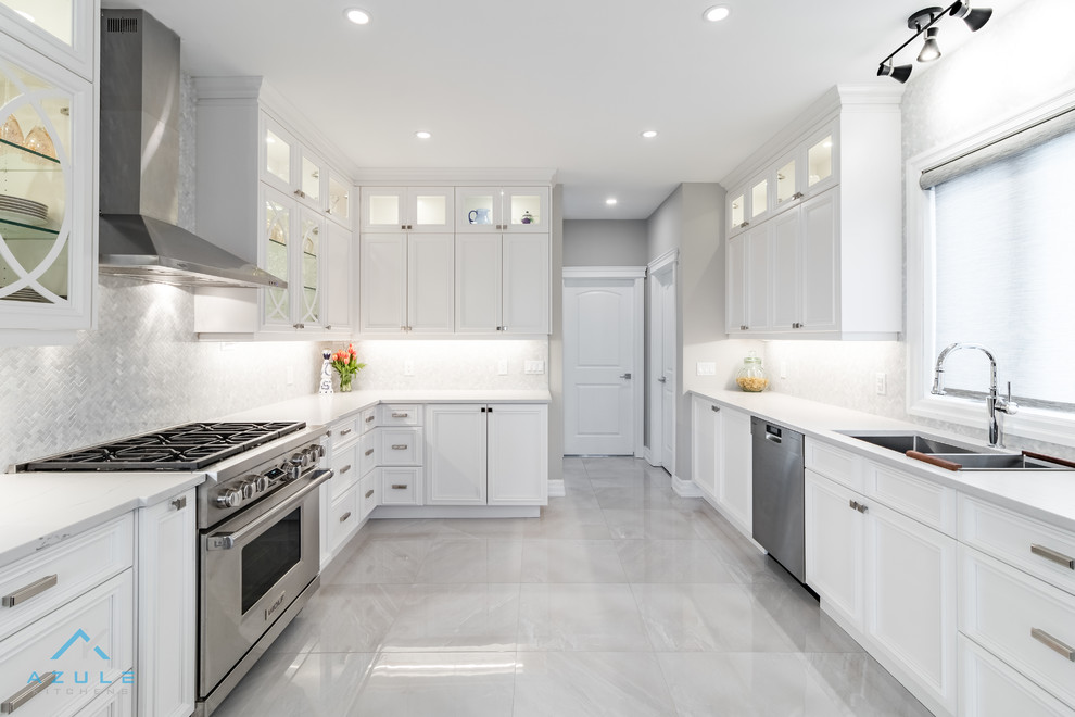 Example of a large transitional u-shaped porcelain tile enclosed kitchen design with recessed-panel cabinets, white cabinets, quartz countertops, white backsplash, marble backsplash, stainless steel appliances, an island and white countertops