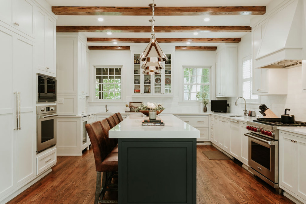 Large transitional u-shaped medium tone wood floor, brown floor and exposed beam eat-in kitchen photo with a single-bowl sink, recessed-panel cabinets, white cabinets, quartz countertops, white backsplash, marble backsplash, stainless steel appliances, an island and white countertops