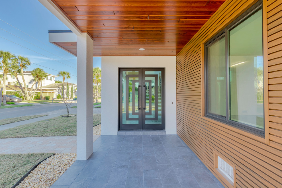 This is an example of an expansive modern front door in Tampa with multi-coloured walls, ceramic floors, a double front door, a metal front door and grey floor.