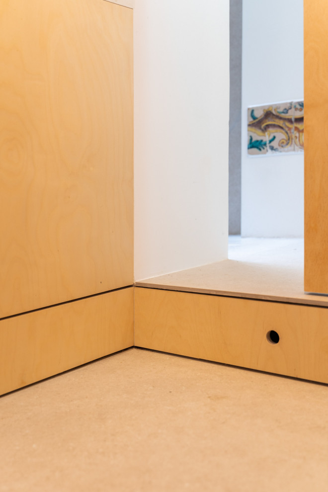 Idées déco pour une petite armoire encastrée rétro en bois clair neutre avec un placard à porte plane, un sol en carrelage de céramique, un sol beige et poutres apparentes.