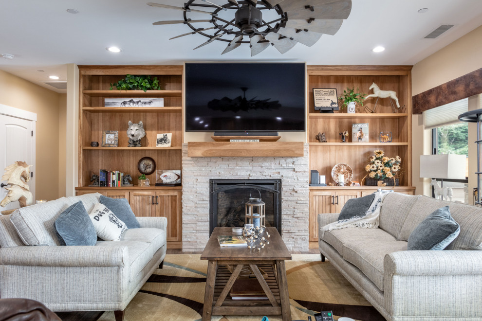 This is an example of a medium sized rustic formal and grey and brown enclosed living room in Sacramento with beige walls, dark hardwood flooring, a standard fireplace, a stacked stone fireplace surround, a wall mounted tv and brown floors.