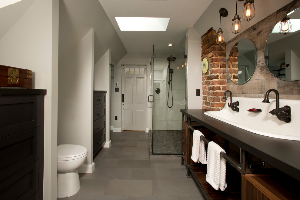 This is an example of a large industrial master bathroom in DC Metro with a trough sink, open cabinets, dark wood cabinets, engineered quartz benchtops, a corner shower, gray tile, porcelain tile, porcelain floors and grey walls.