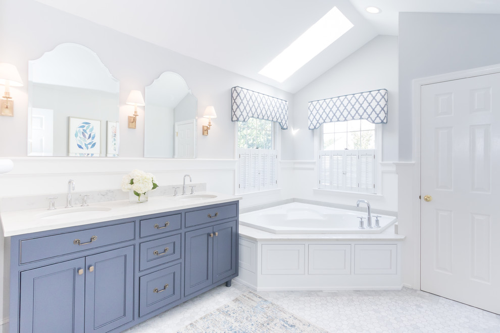 Inspiration for a transitional master bathroom in Philadelphia with blue cabinets, a corner tub, white tile, ceramic tile, white walls, ceramic floors, an undermount sink and marble benchtops.