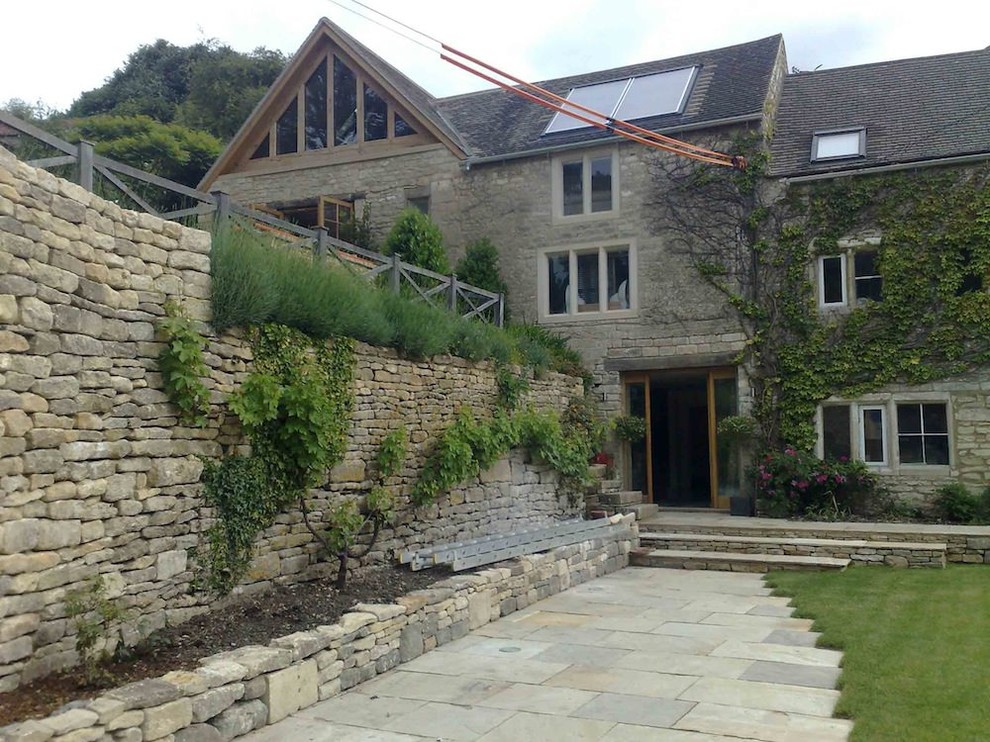 Design ideas for a mid-sized modern three-storey exterior in Gloucestershire with stone veneer.