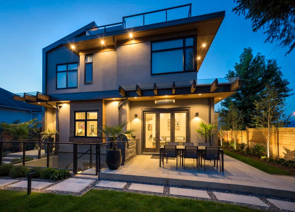 Photo of a mid-sized contemporary three-storey grey house exterior in Vancouver with mixed siding and a flat roof.