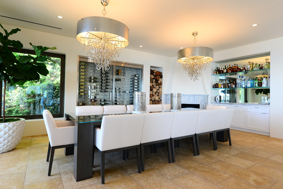 This is an example of a large beach style open plan dining in Los Angeles with white walls, limestone floors, a corner fireplace, a stone fireplace surround and beige floor.