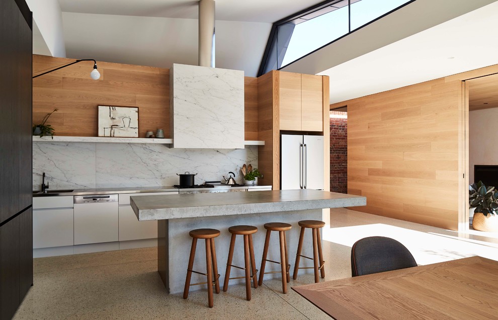 This is an example of a contemporary single-wall eat-in kitchen in Melbourne with flat-panel cabinets, white cabinets, grey splashback, white appliances, with island and grey benchtop.