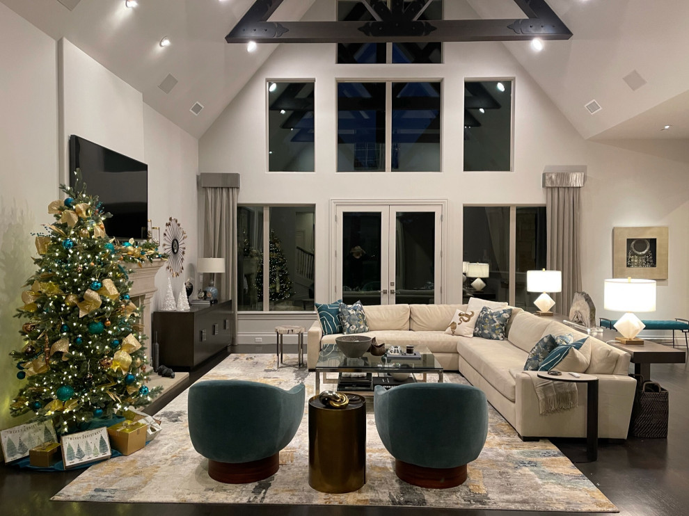 Expansive contemporary open plan games room in Dallas with white walls, dark hardwood flooring, a standard fireplace, a concrete fireplace surround, a wall mounted tv, brown floors and a vaulted ceiling.
