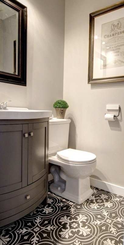 Design ideas for a small traditional powder room in Montreal with shaker cabinets, grey cabinets, a two-piece toilet, grey walls, ceramic floors, a console sink, solid surface benchtops and multi-coloured floor.