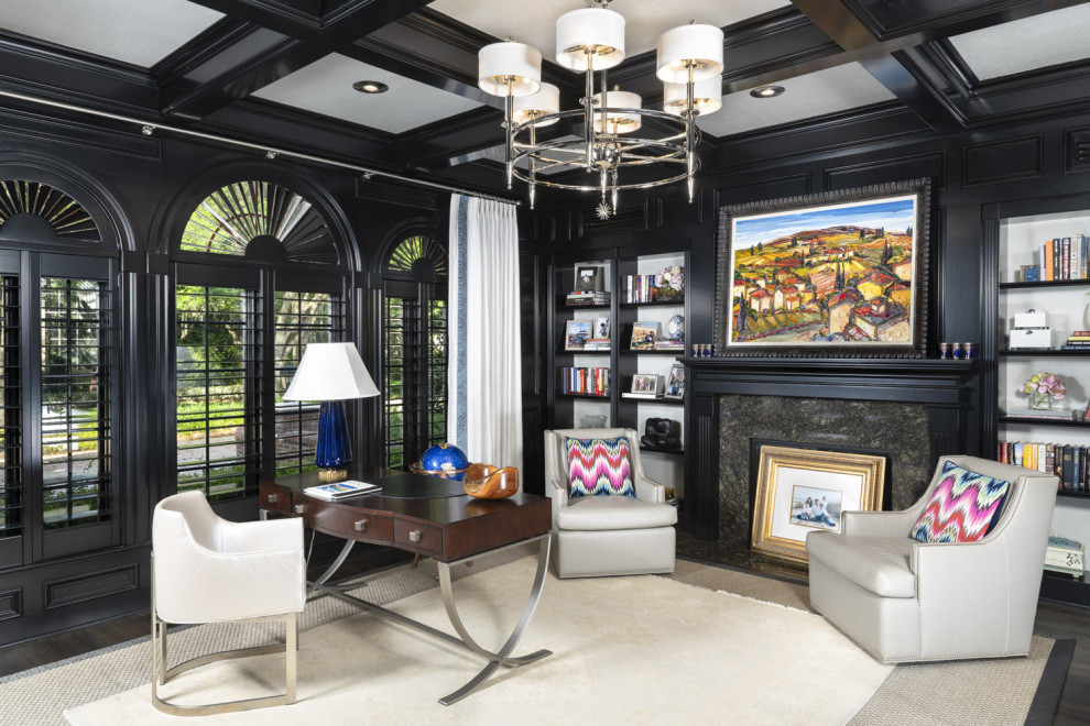 Mid-sized transitional study room in Tampa with black walls, dark hardwood floors, a standard fireplace, a stone fireplace surround, a freestanding desk, brown floor, coffered and wallpaper.