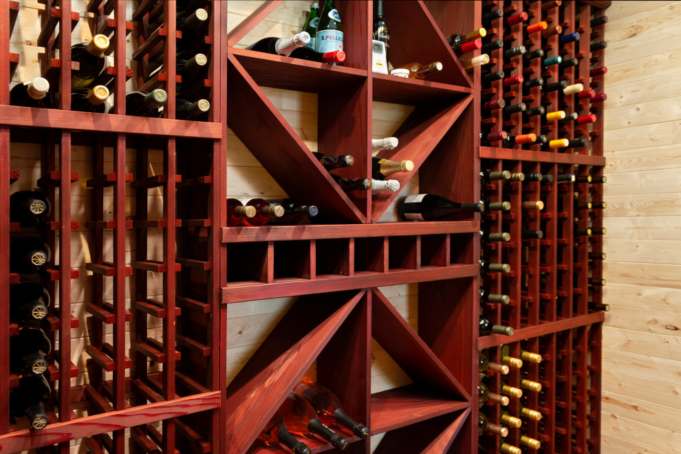 Mid-sized wine cellar in Milwaukee with medium hardwood floors, storage racks and brown floor.