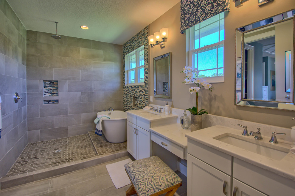 Inspiration for a mid-sized arts and crafts master bathroom in Orlando with shaker cabinets, white cabinets, a freestanding tub, an alcove shower, beige tile, stone slab, beige walls, porcelain floors, an undermount sink, engineered quartz benchtops, beige floor and an open shower.