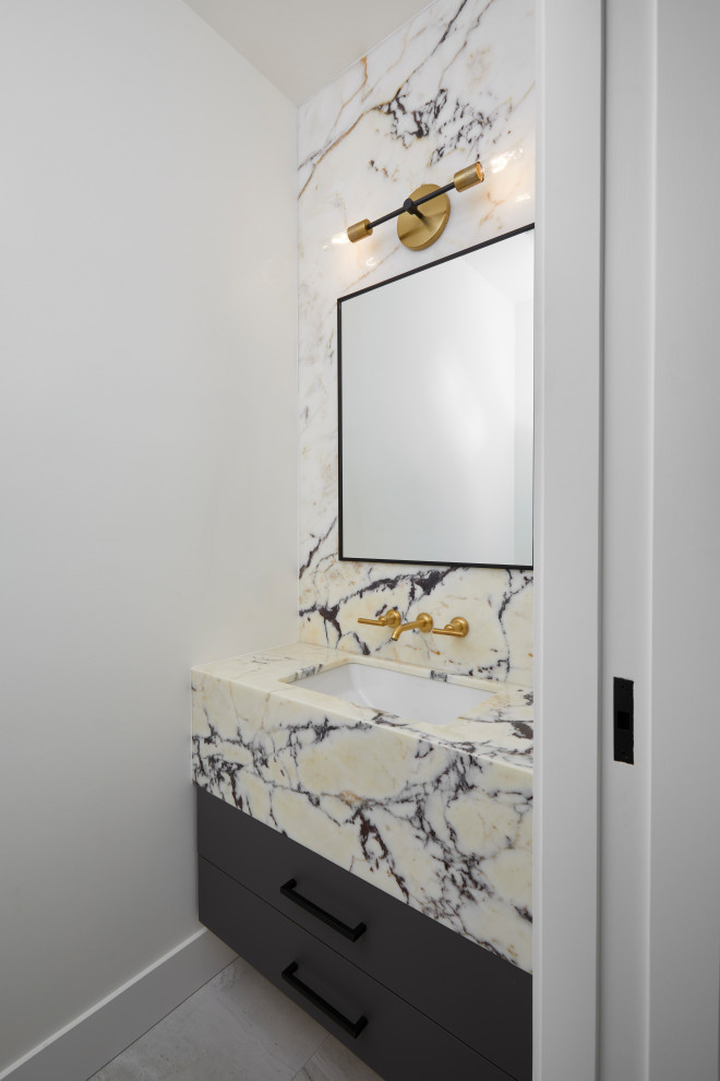 Cette image montre un grand WC et toilettes traditionnel avec un placard à porte plane, des portes de placard noires, un sol en carrelage de céramique, un lavabo intégré, un plan de toilette en marbre, un sol gris, un plan de toilette jaune et meuble-lavabo suspendu.