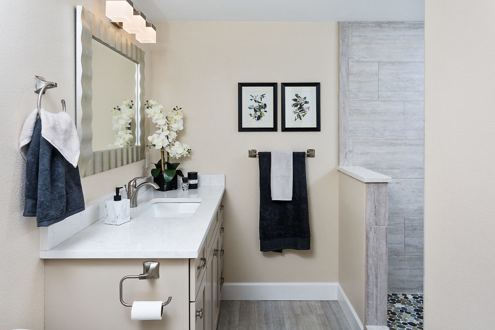 Example of a transitional bathroom design with shaker cabinets, white cabinets, beige walls, an undermount sink and quartz countertops